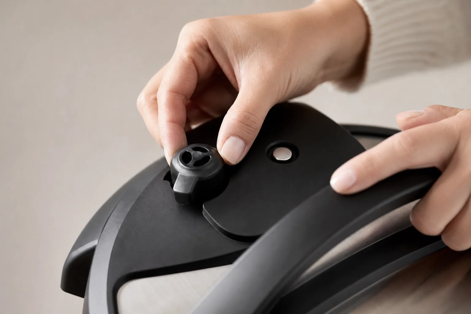 Hands holding an Instant Pot lid showing the steam release valve mechanism