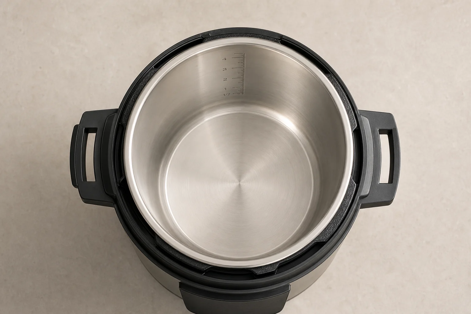 Open pressure cooker showing flat bottom insert with measurement markings