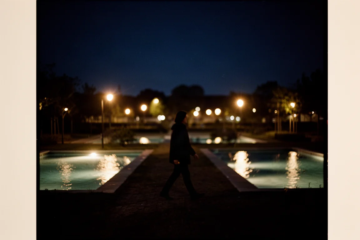 Night scene with people silhouetted against warm street lights