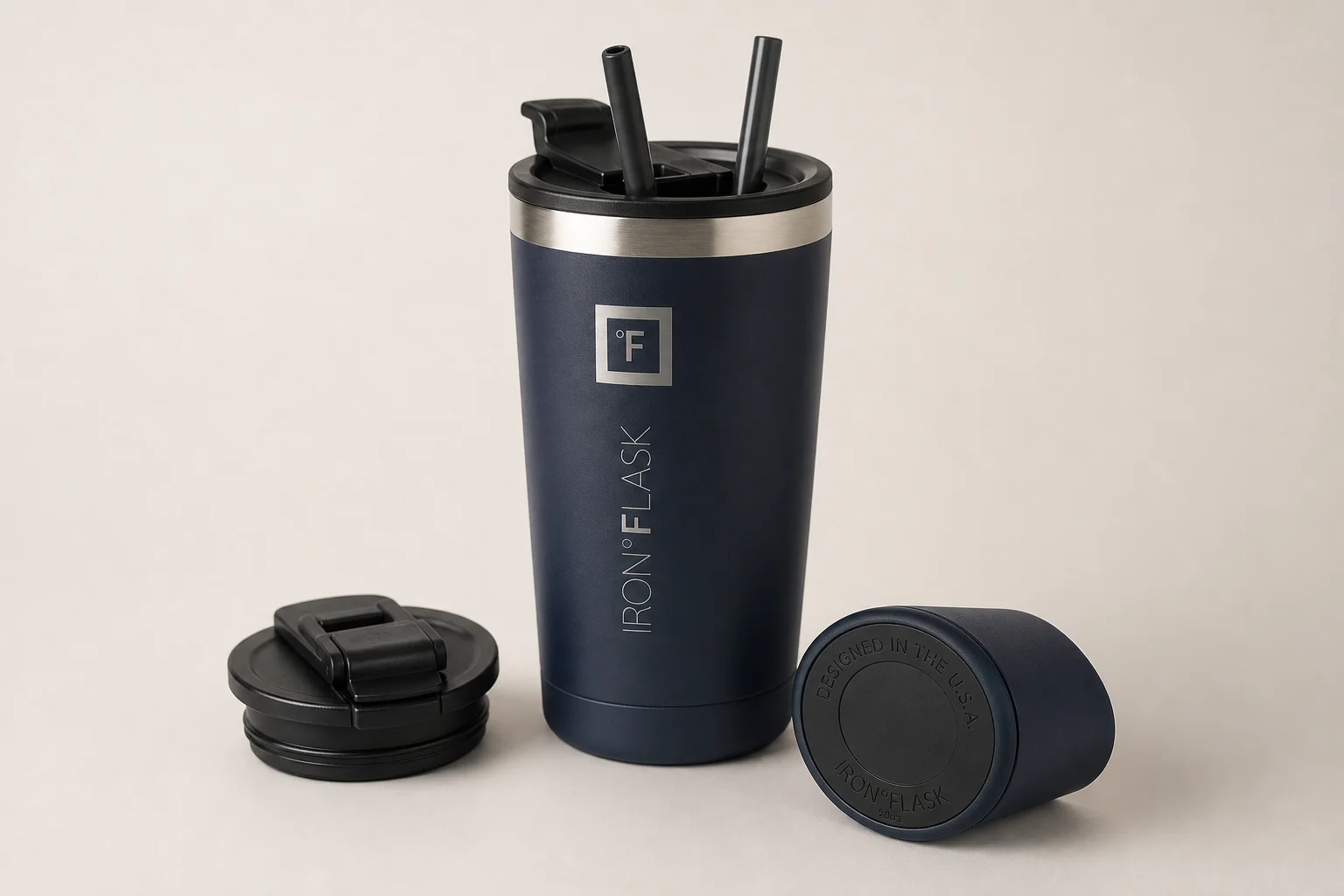 Cinq mugs de voyage disposés par ordre de classement sur une surface en béton