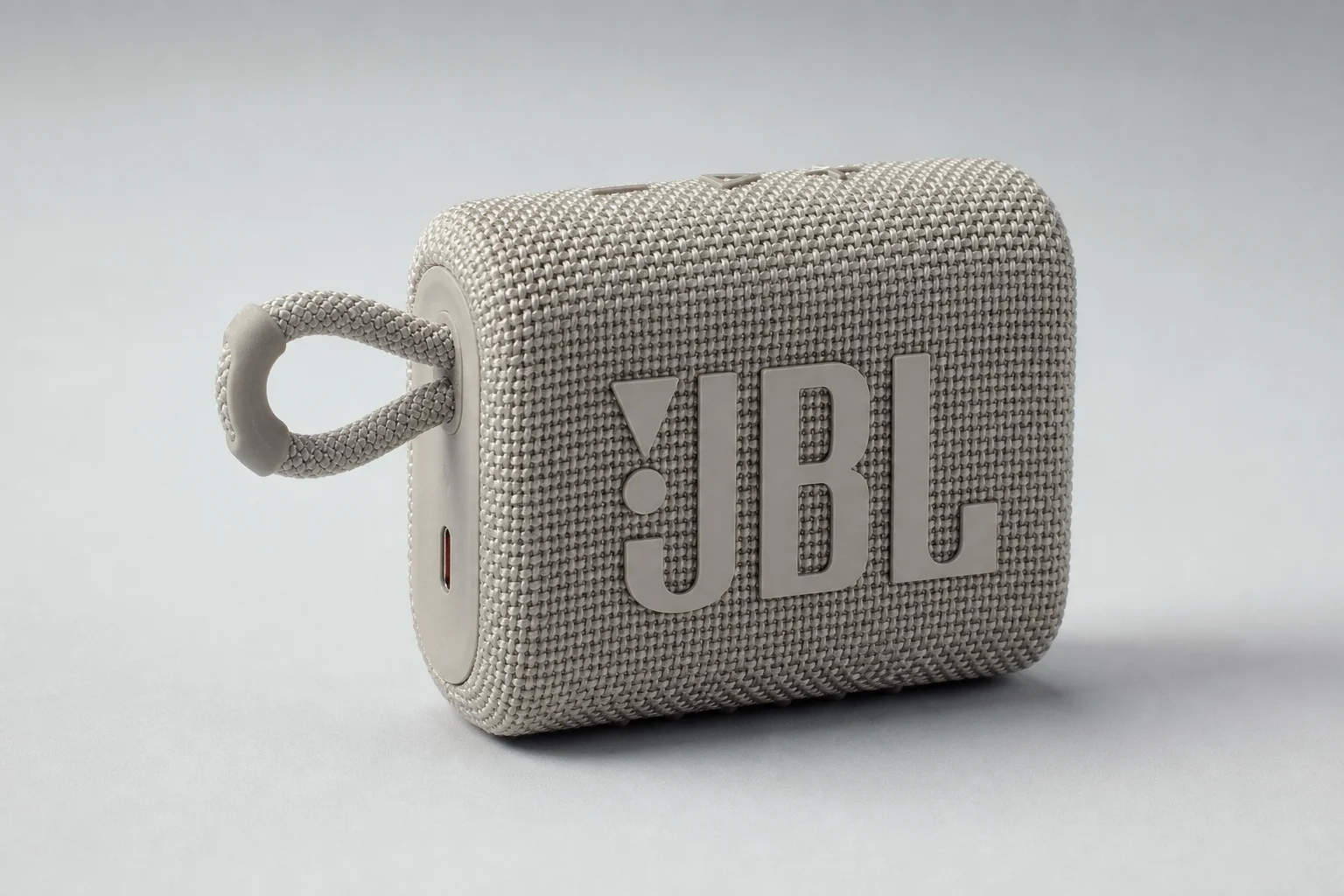 Cinco altavoces Bluetooth económicos dispuestos sobre una superficie de hormigón
