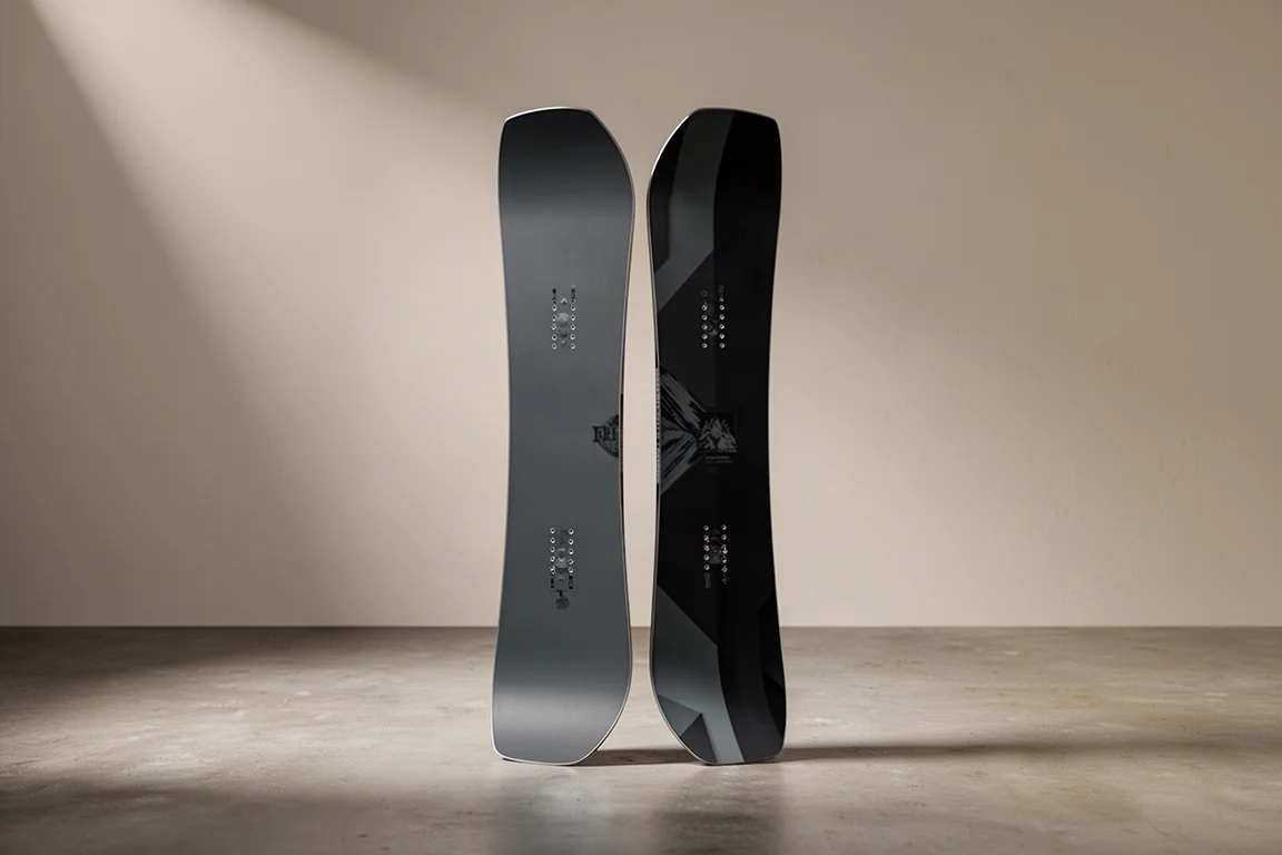 Split snowboard standing upright in two joined halves on a matte concrete surface