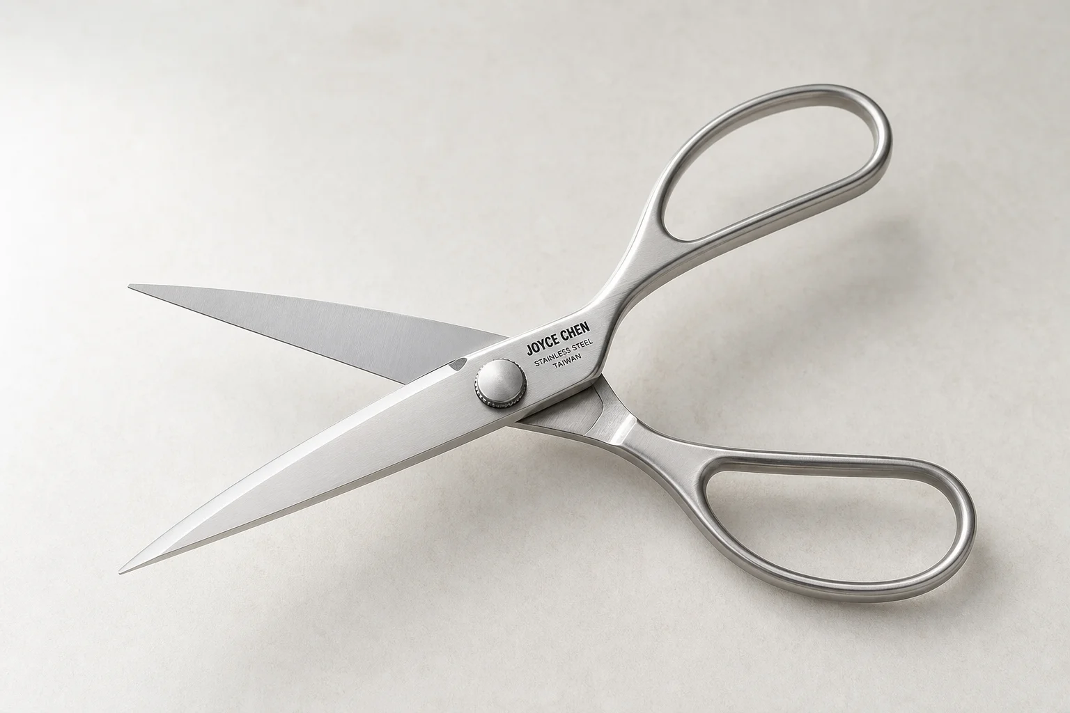 Professional kitchen knives and tools arranged on concrete surface