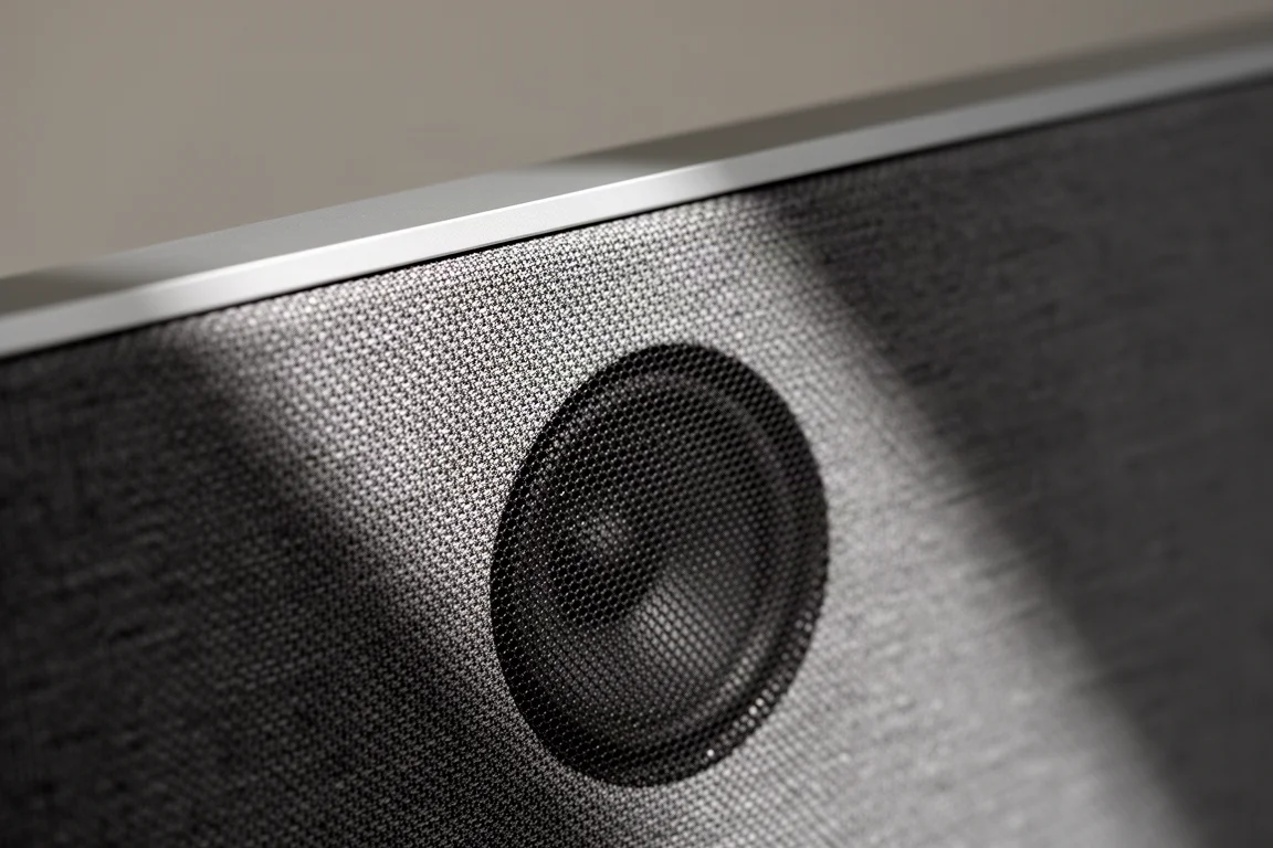 布面 soundbar 網罩特寫,後方隱約可見單元陰影