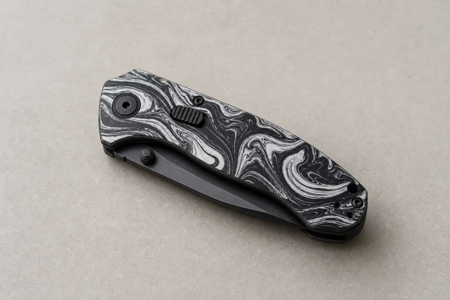 Premium folding knives with titanium handles and Damasteel blades on a dark slate surface
