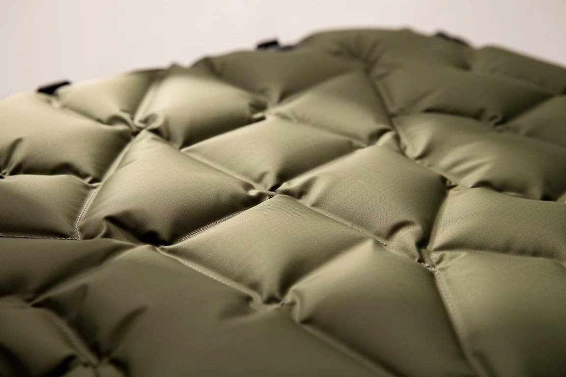 Close-up of quilted sleeping pad surface with diamond weld lines and raking light