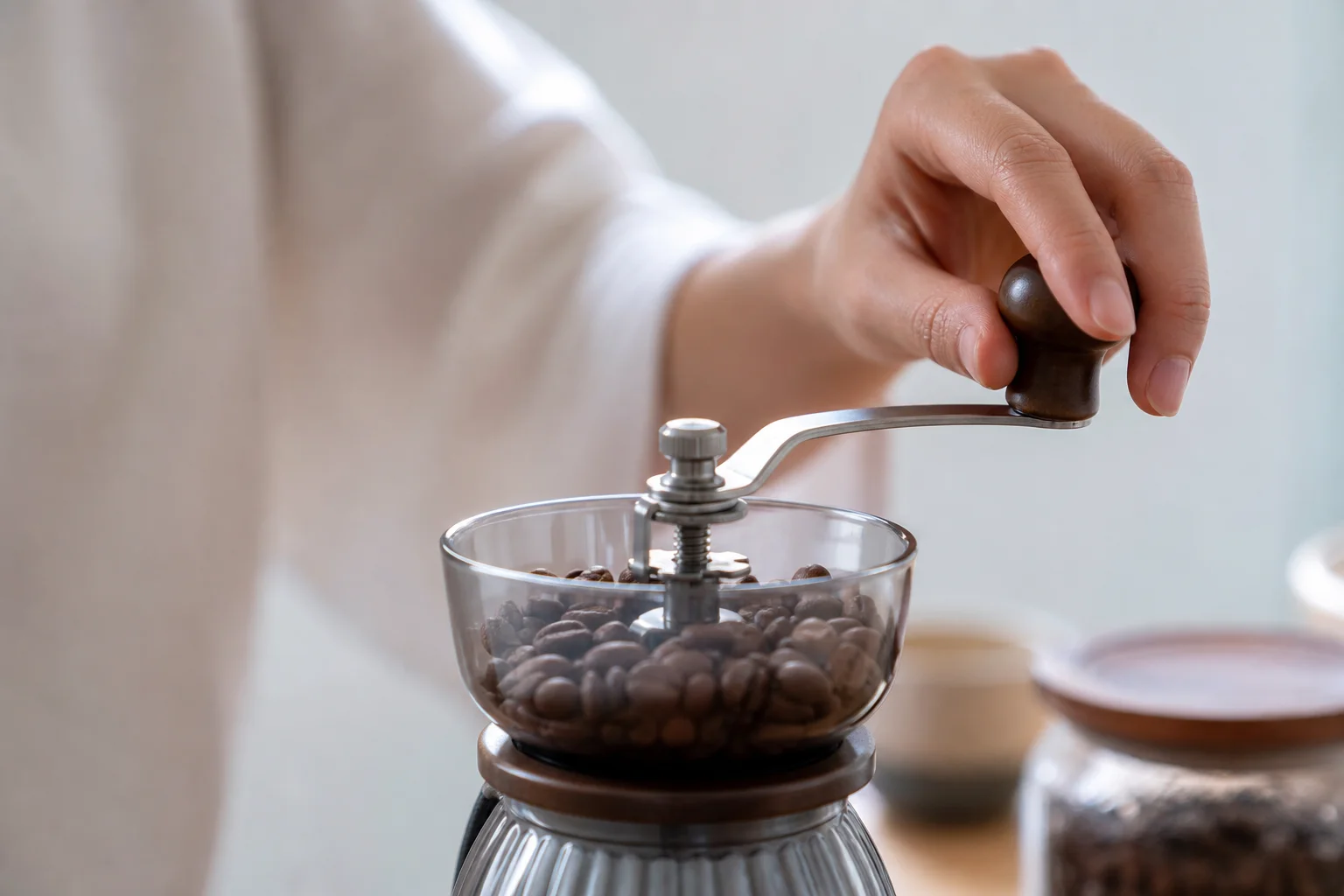 Close-up of hand grinding coffee beans in a manual grinder