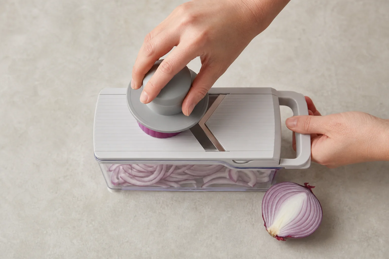 Hands using a compact chopper to slice vegetables over a food container