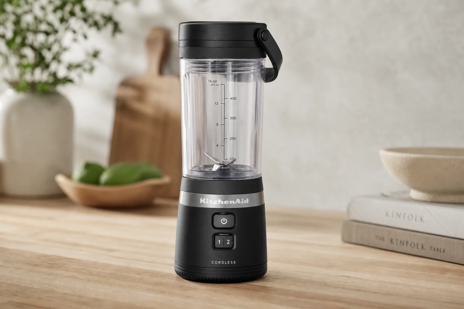 Five cordless blenders arranged on grey concrete surface