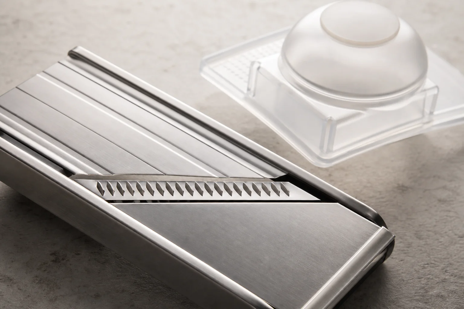 Stainless steel blade of a mandoline slicer with protective plastic handguard