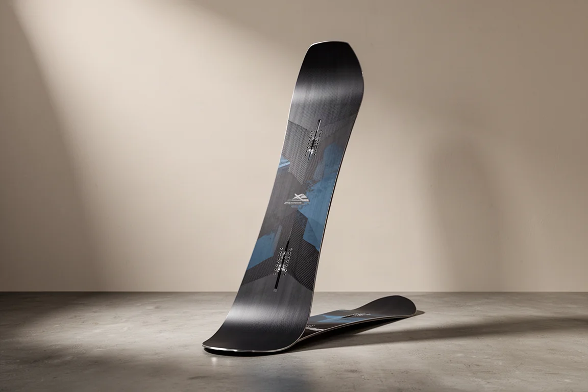 Riktad freeride-snowboard med matt mörk topsheet som står på ett betonggolv