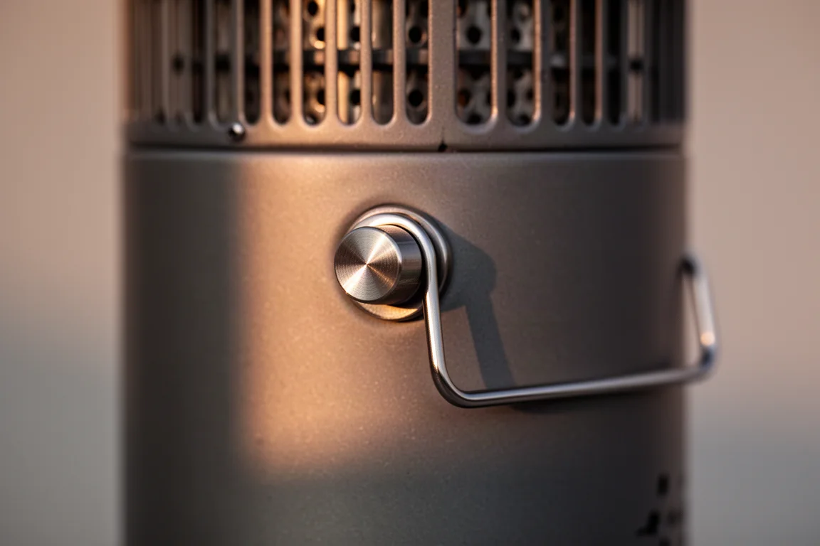 Gros plan sur un bouton de réglage métallique et un anneau à tirer sur un corps de chauffage de camping ventilé