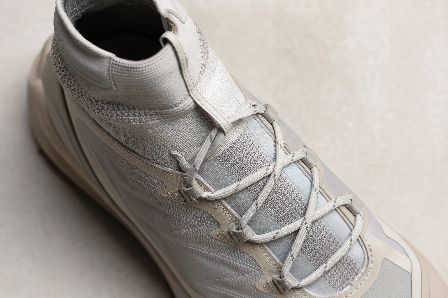 Close-up of trail shoe upper showing gaiter collar and lacing system detail