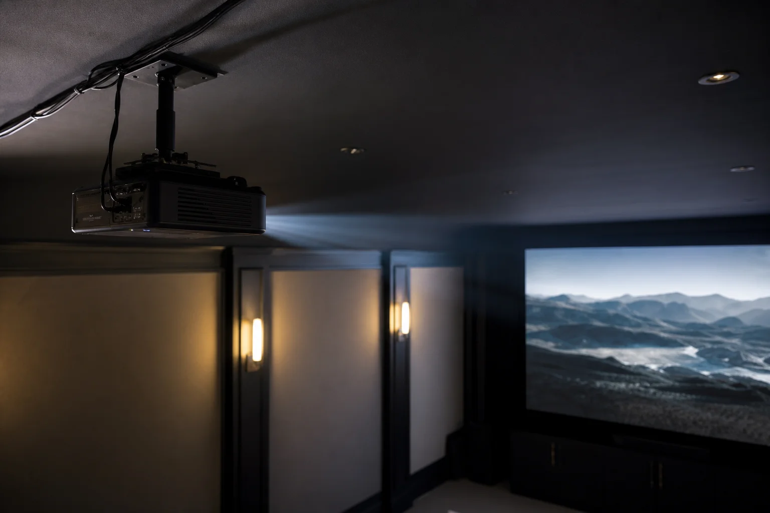 An der Decke montierter herkömmlicher Projektor, der einen Lichtstrahl in einen dunklen Raum wirft