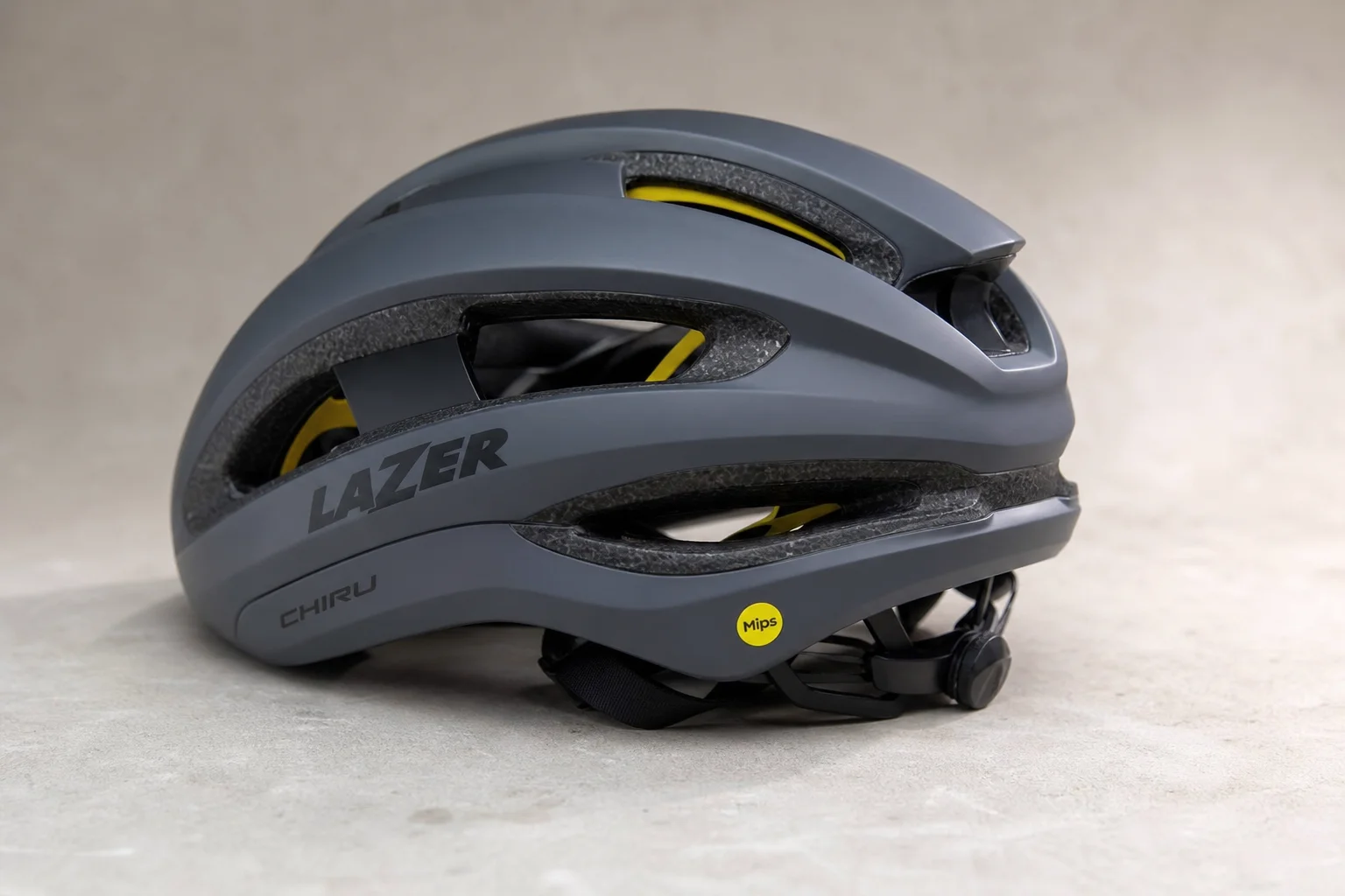 Five bike helmets of varying styles and price points arranged on concrete