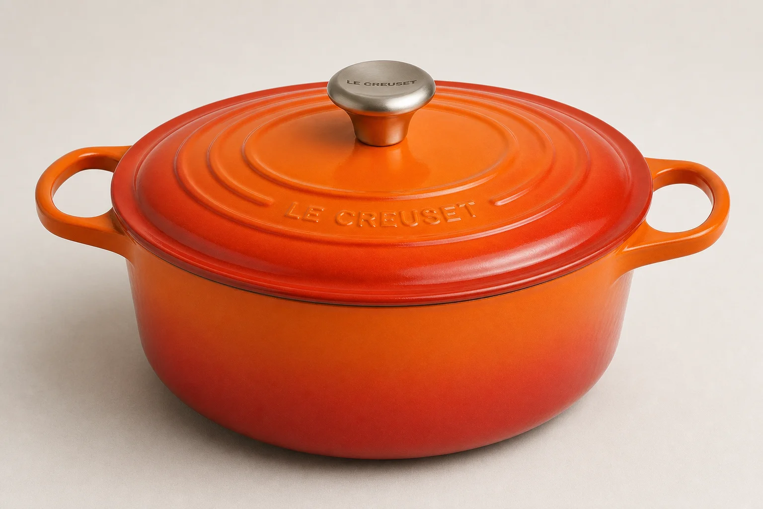 Collection of nine Dutch ovens in various colors and finishes arranged on neutral backdrop