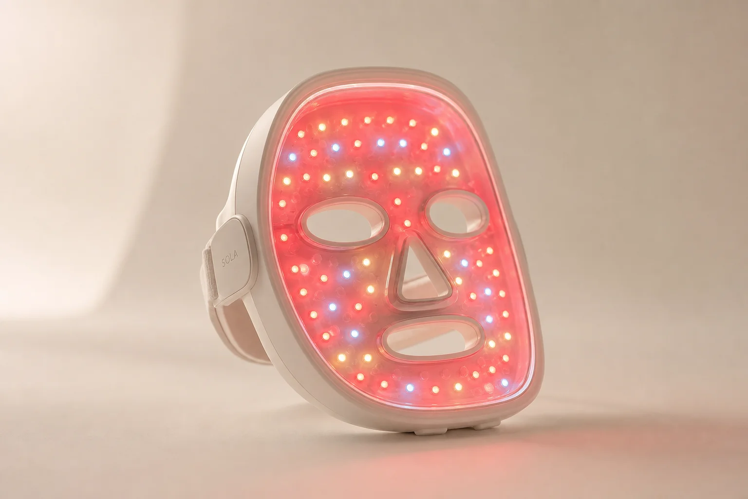Maschera per terapia a luce LED con array di luci rosse illuminate su sfondo neutro