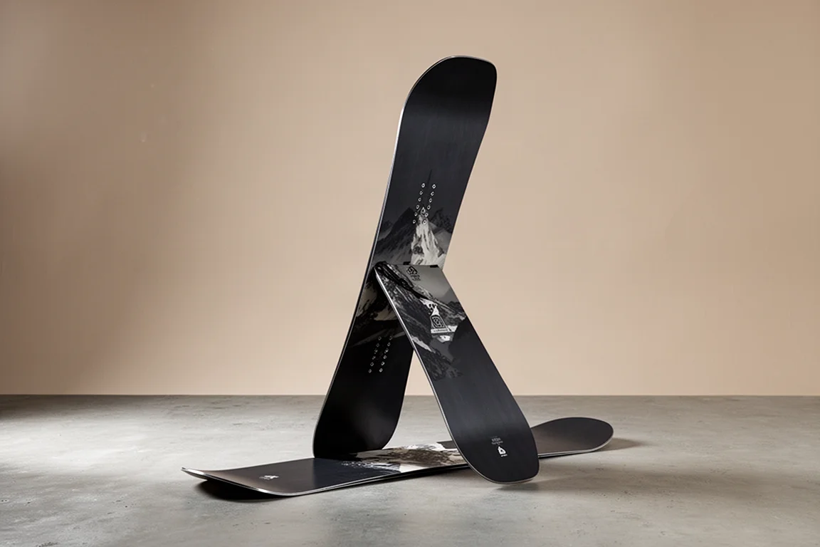 Directional freeride snowboard standing upright on a matte concrete surface