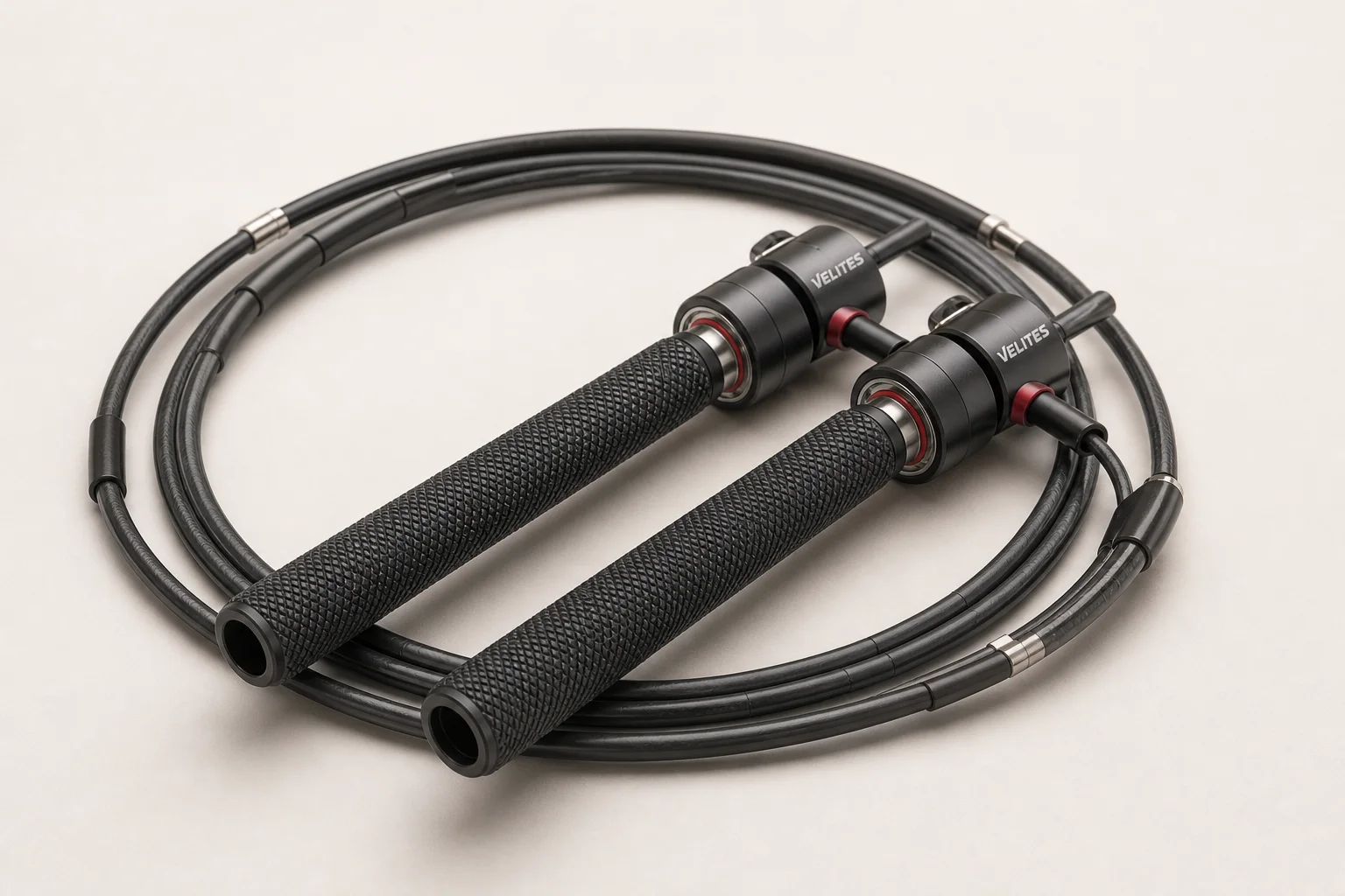 Five jump ropes with different handle styles and cable designs arranged on concrete