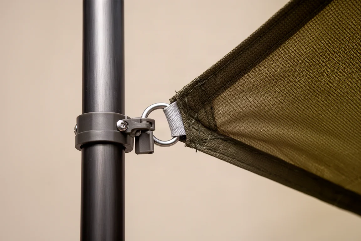 Close-up de um arco de barraca grosso passado por um ilhó metálico ao lado de um clipe