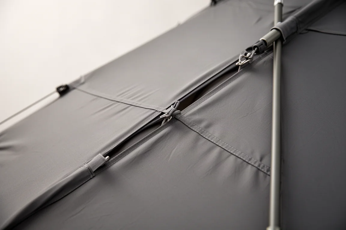 Clips pulled through slits in a grey fabric panel and attached to a tent pole