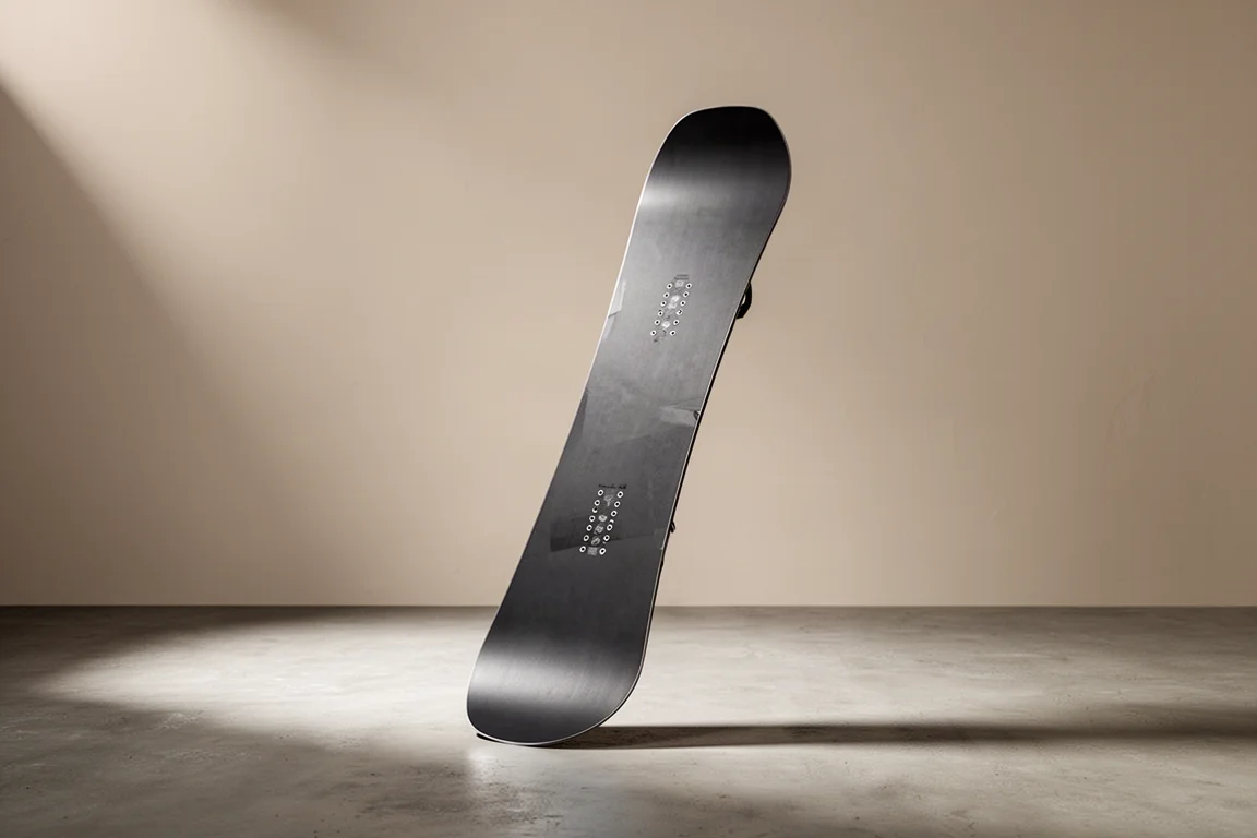 Snowboard with blunt nose and tail standing upright on concrete surface