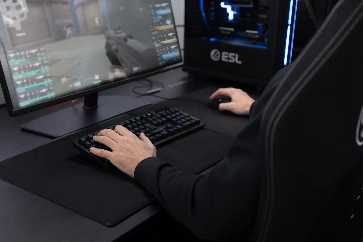 Esports player at gaming desk with mouse and keyboard during competitive match