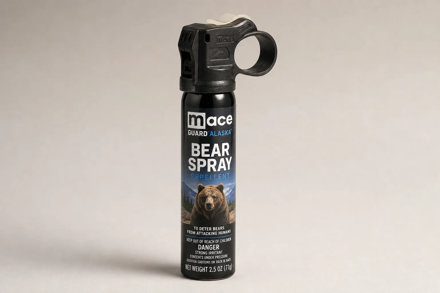 Five bear spray cans of varying sizes arranged on concrete surface