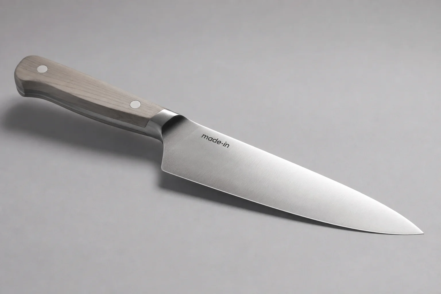 四把主廚刀斜向排列在水泥面上：Misen、Made-In、Victorinox 與 Shun