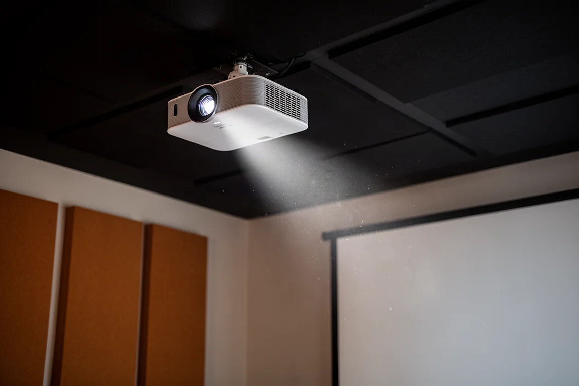 Projecteur fixé au plafond projetant un faisceau doux dans un home cinema sombre