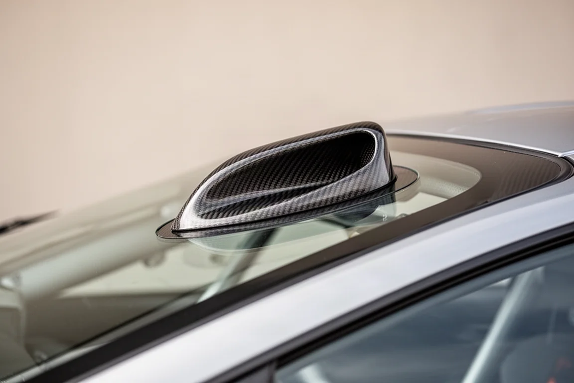 Gros plan sur le petit conduit snorkel s'élevant de la lunette arrière d'une supercar