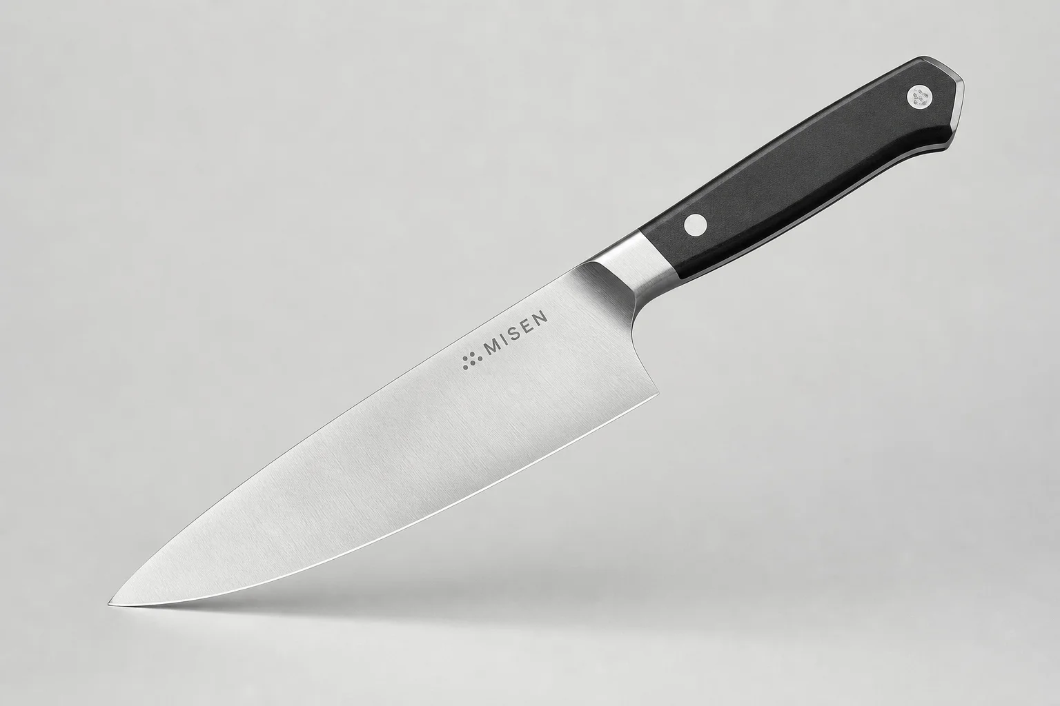 四把主廚刀斜向排列在水泥面上：Misen、Made-In、Victorinox 與 Shun