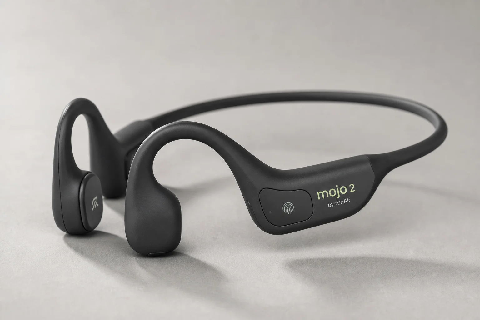 Six bone conduction headphones arranged on concrete surface showing different models and designs