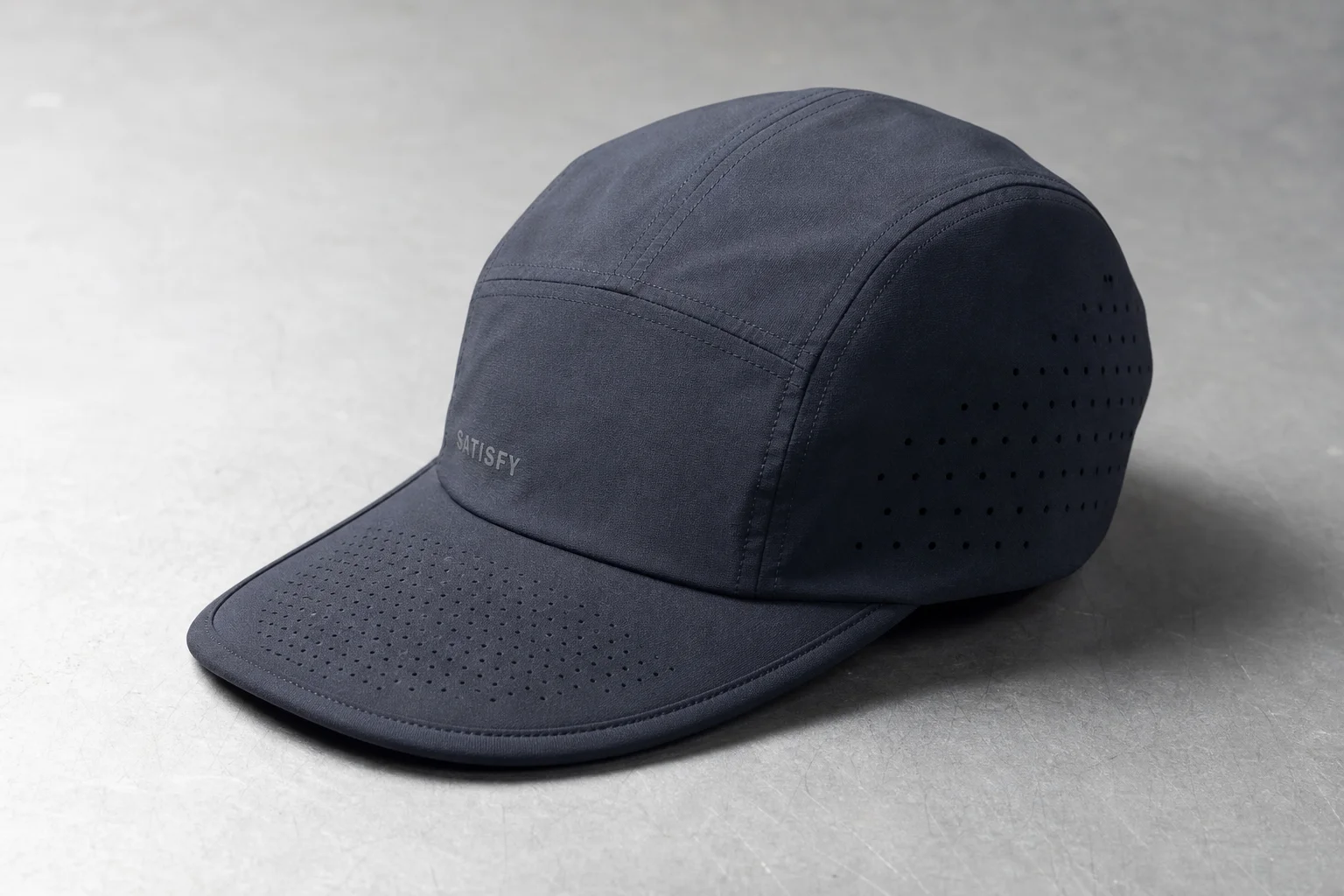Una collezione di nove cappellini da corsa in vari stili e colori su uno sfondo neutro