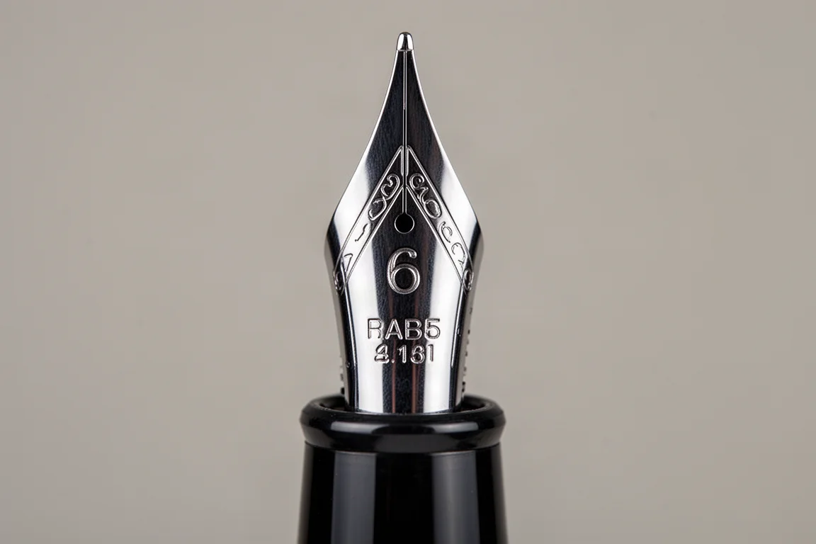 Plume en acier d'un stylo plume en gros plan montrant les gravures et l'alignement des brins