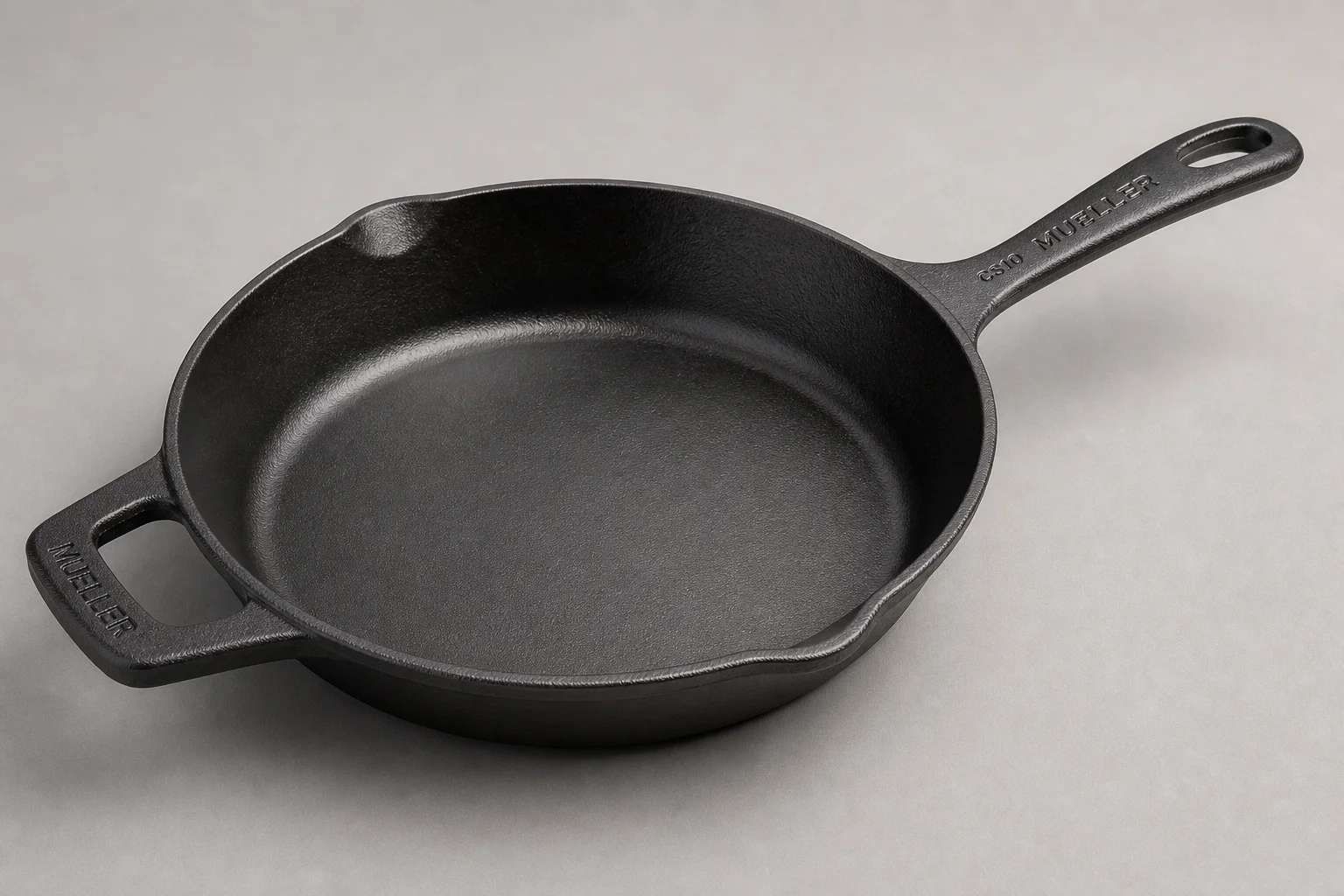 Five cast iron skillets arranged on a wooden surface showing different styles and finishes