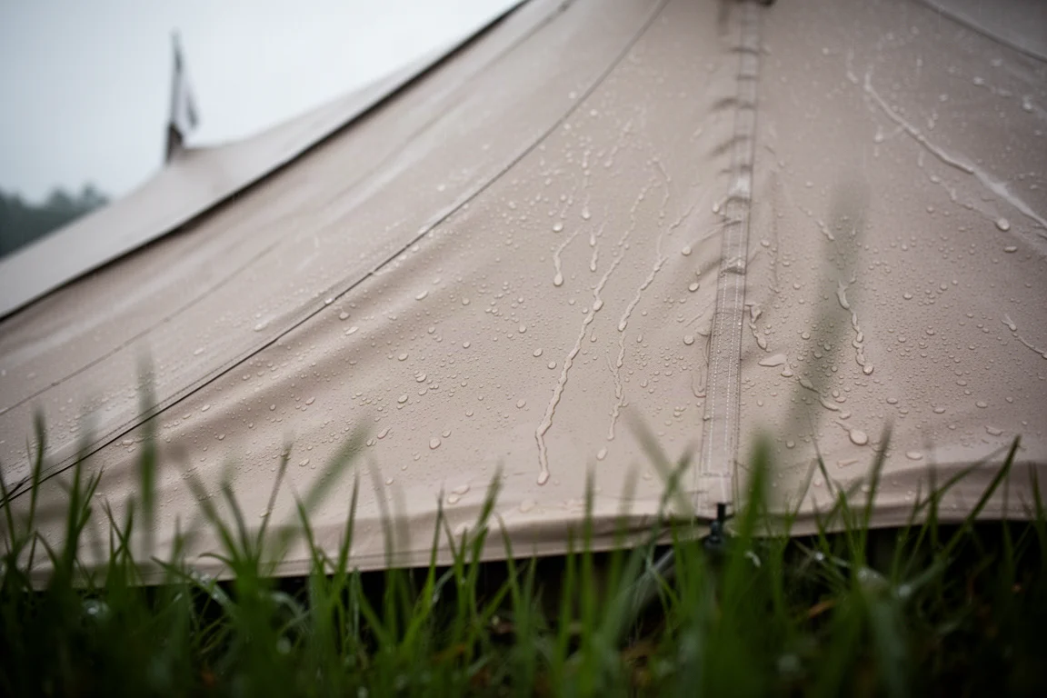 Rain beading and running down the taut fabric wall of a large tent