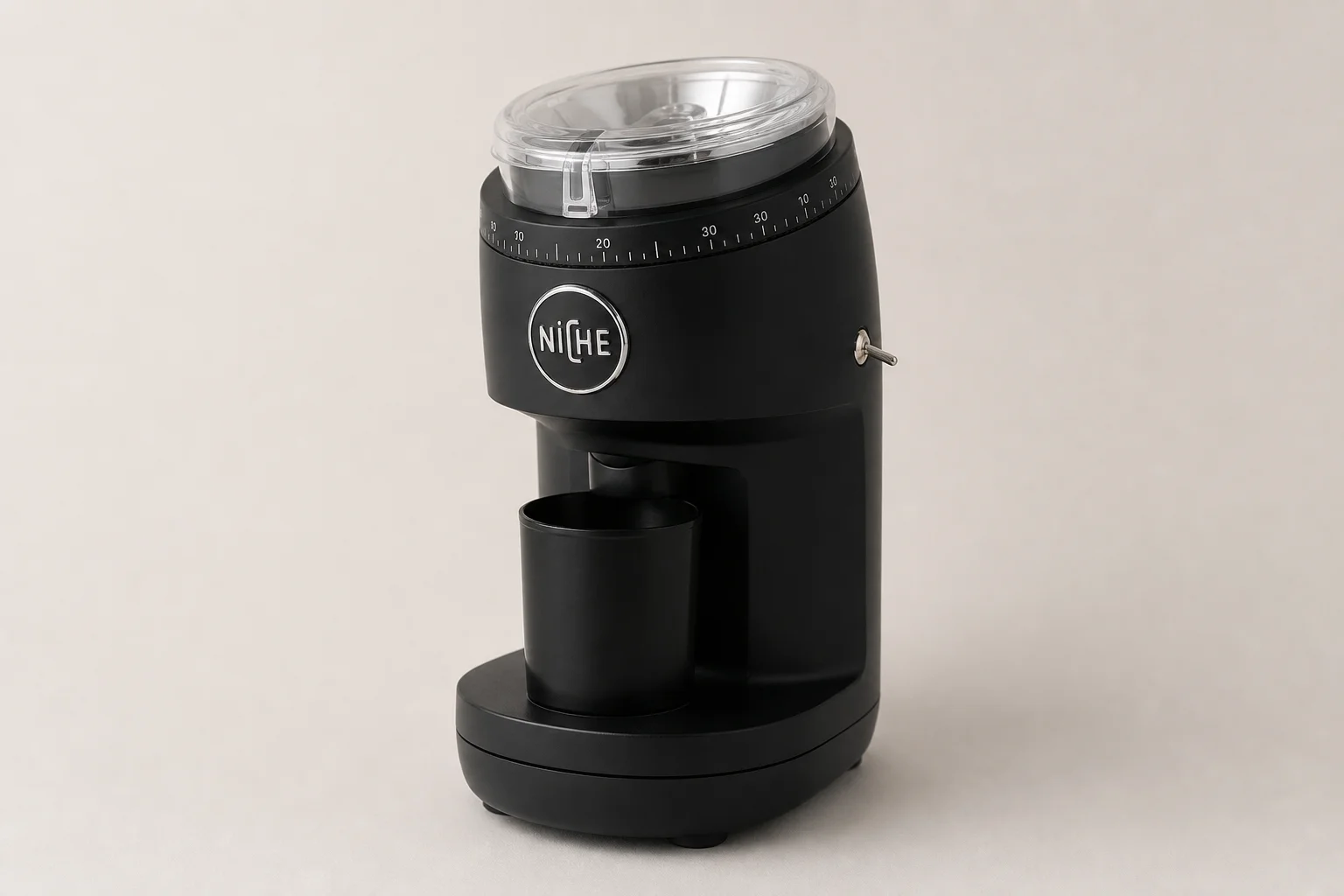Seven espresso grinders of various sizes and styles arranged on concrete surface