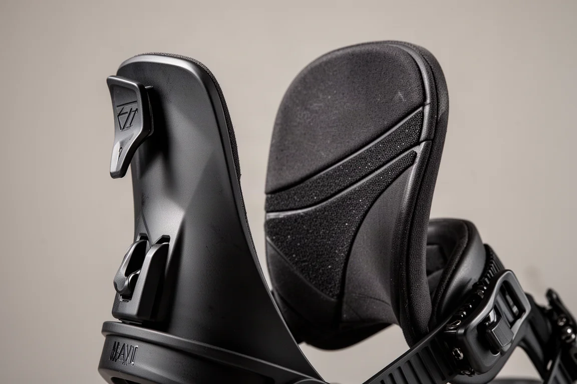 Close-up of a snowboard binding highback with forward lean tab and padded grip