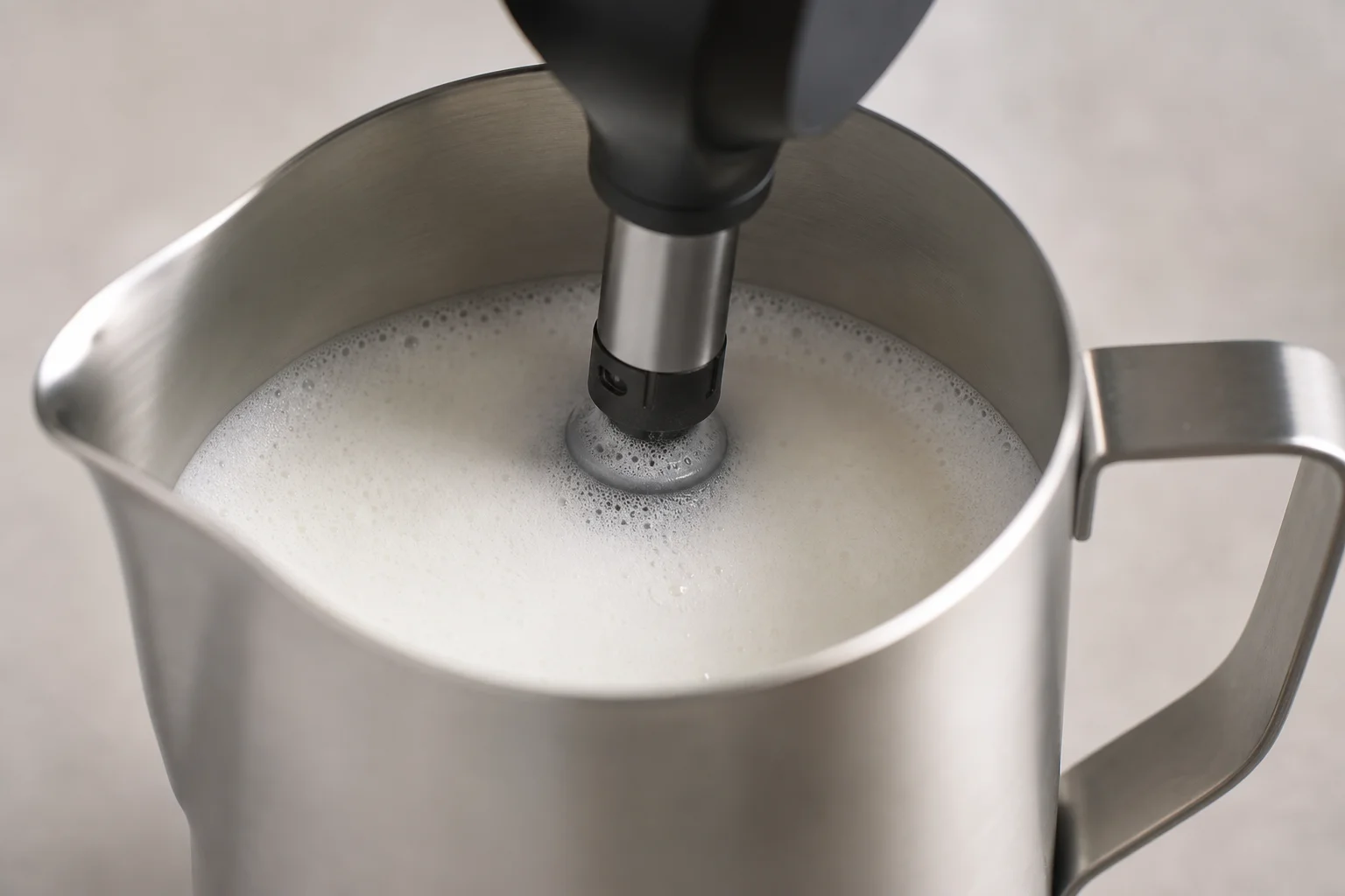 Milk frother attachment creating microfoam in stainless steel pitcher