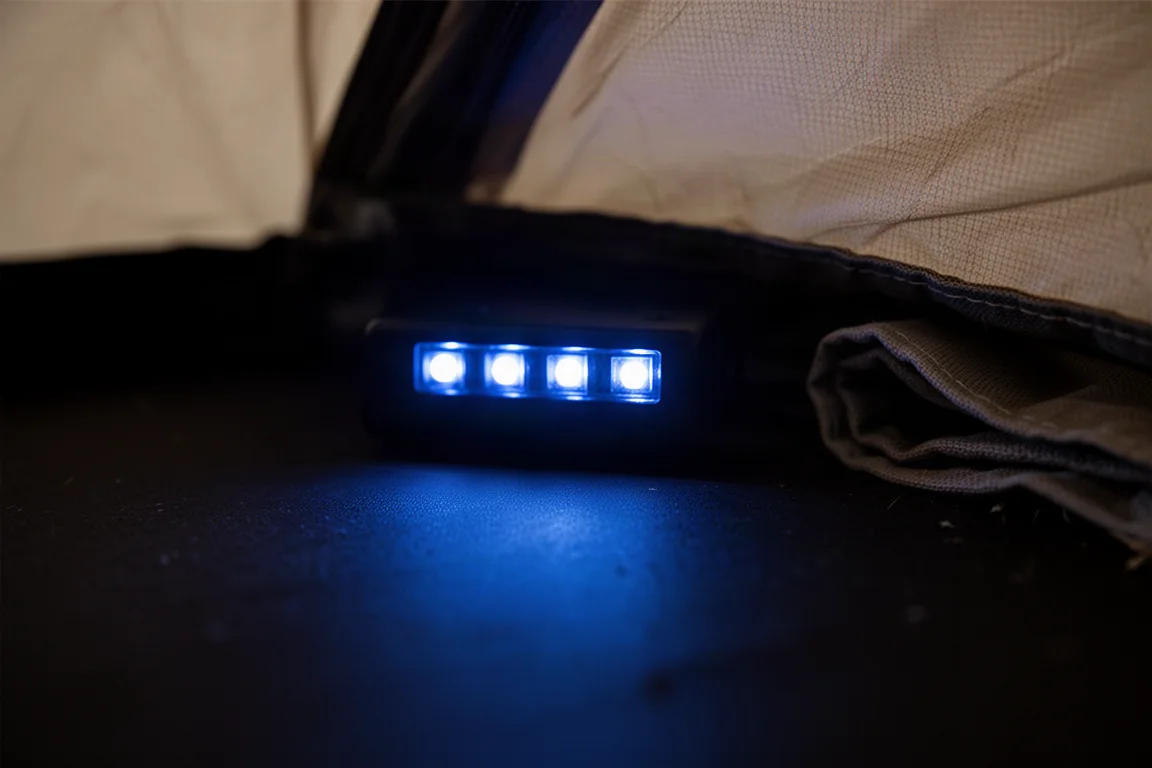 Acampamento na hora azul com um celular carregando a partir de um power bank sobre uma pedra plana