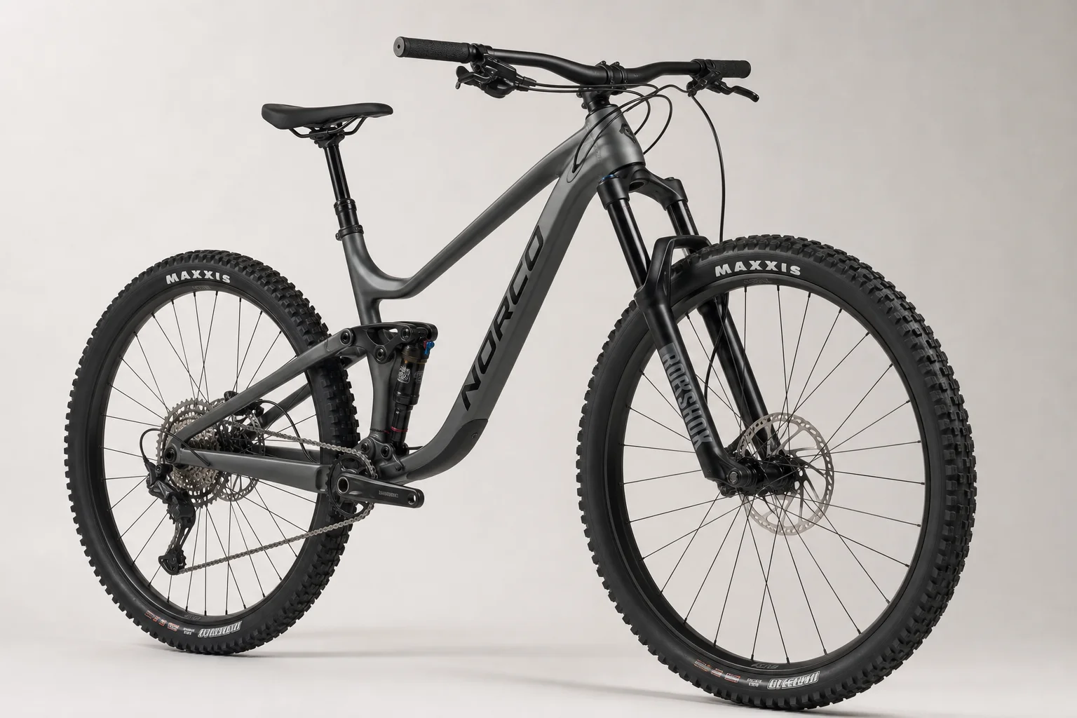 Sechs vollgefederte Mountainbikes auf einer grauen Oberfläche angeordnet