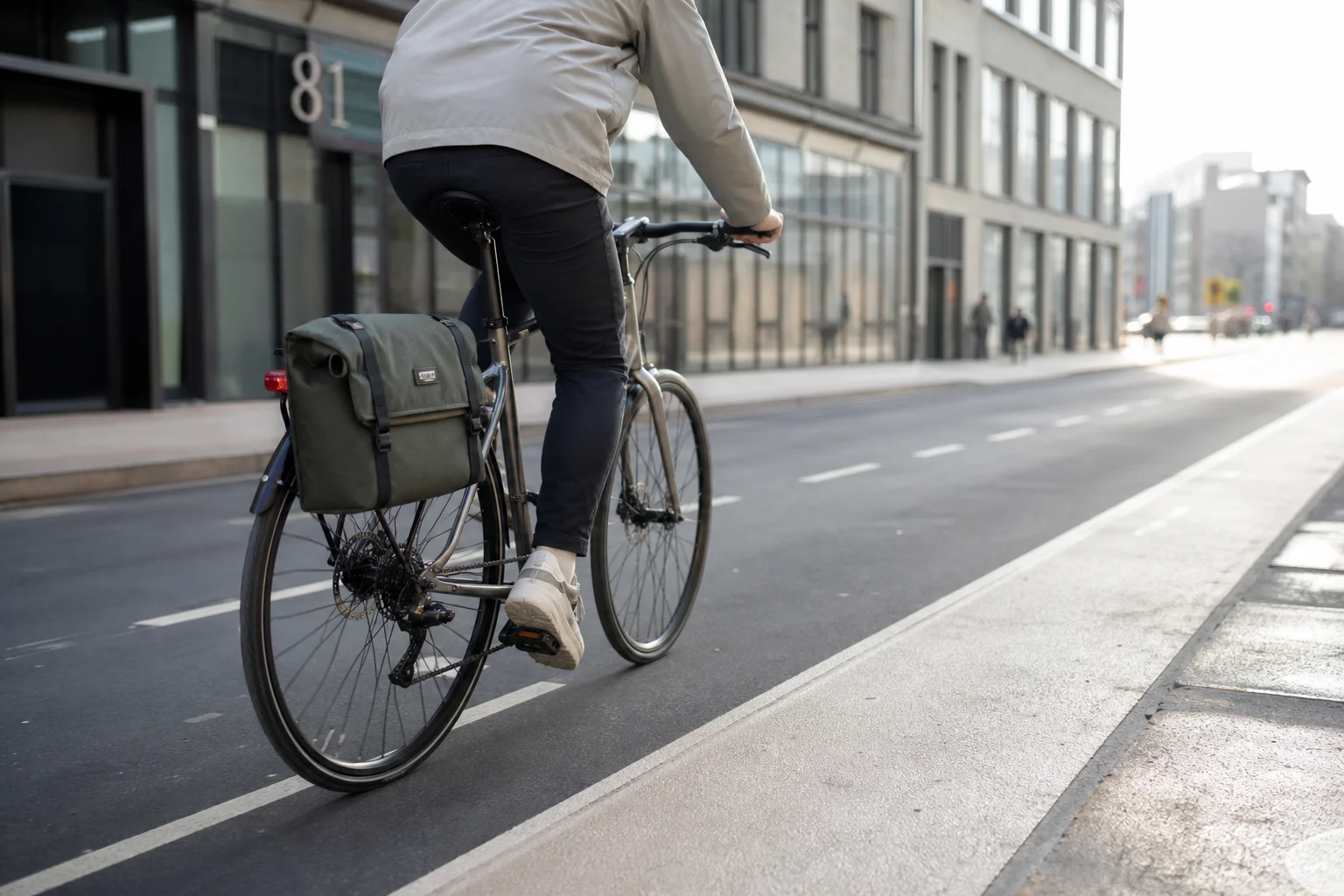Cycliste en ville avec la sacoche montée sur le porte-bagages arrière