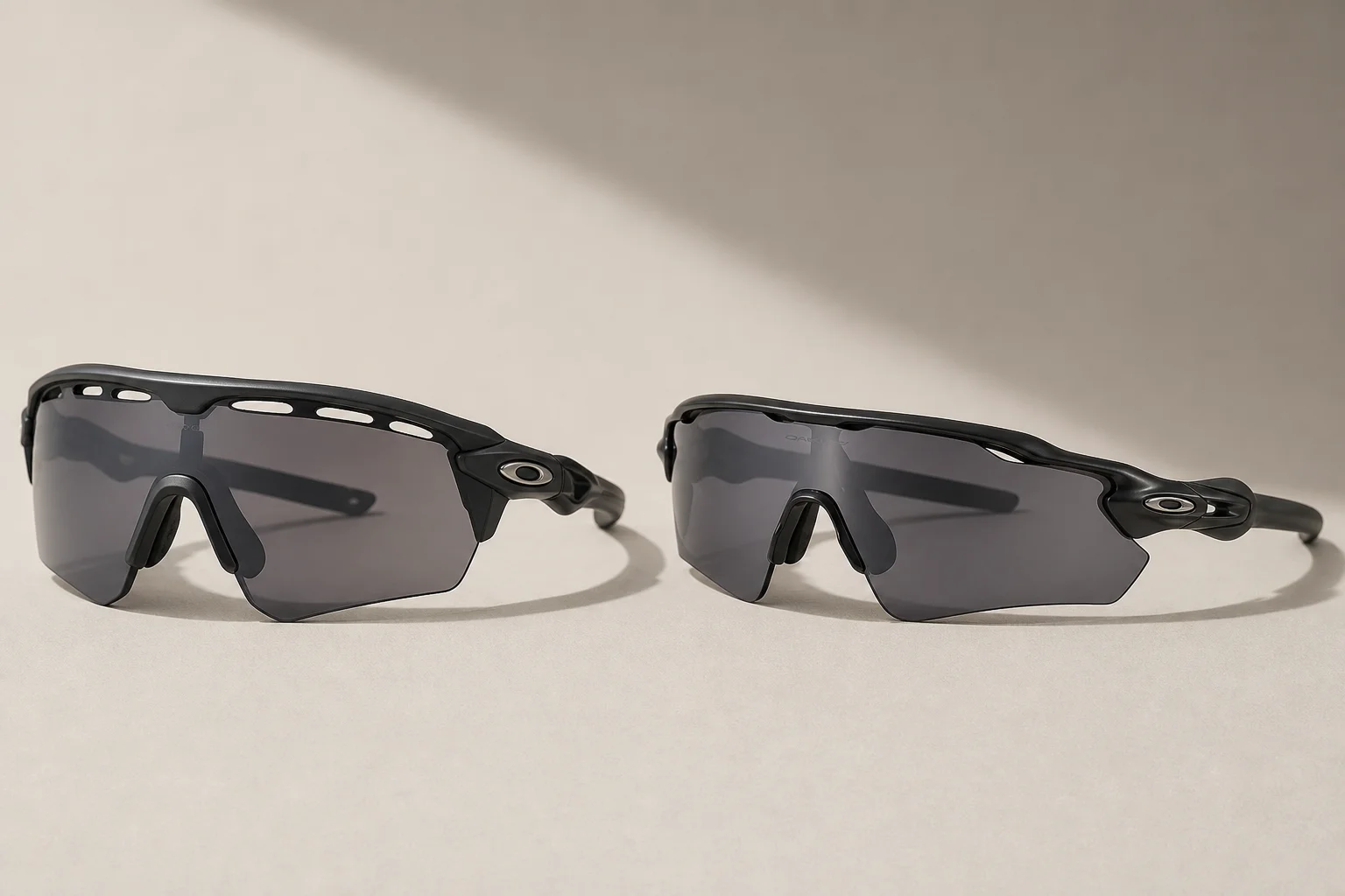 Oakley Sphaera och Radar EV Path sportglasögon sida vid sida på en neutral bakgrund