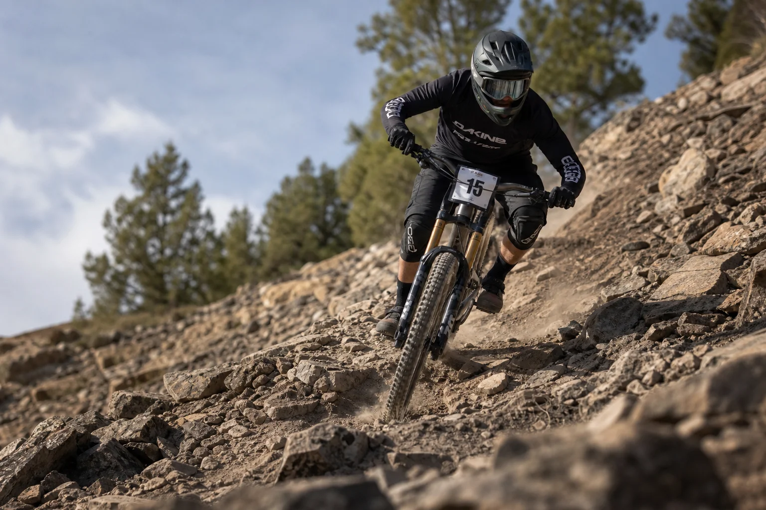 Downhill-Mountainbiker auf einem steilen, felsigen Trail-Abschnitt