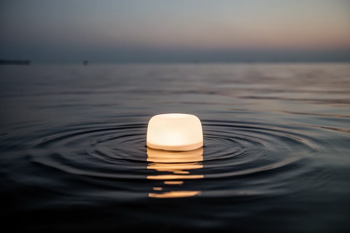 Leuchtendes Licht treibt auf der Oberfläche von ruhigem Wasser