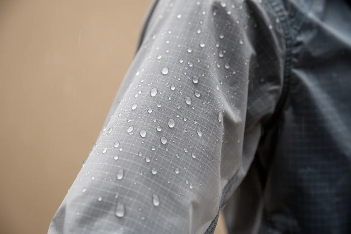 Light drizzle beading on a thin ripstop jacket sleeve
