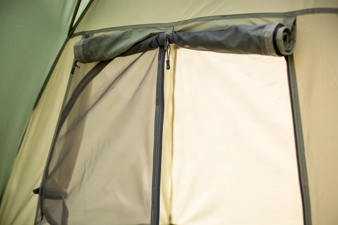 Nahaufnahme einer Zeltür mit geschlossenem Mesh-Panel und aufgerolltem Stoffpanel
