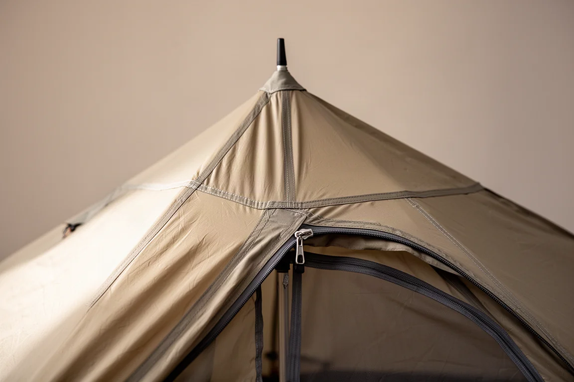 Primo piano dell'apice di una tenda con bastoncini e la porta dell'abside con cerniera parzialmente aperta