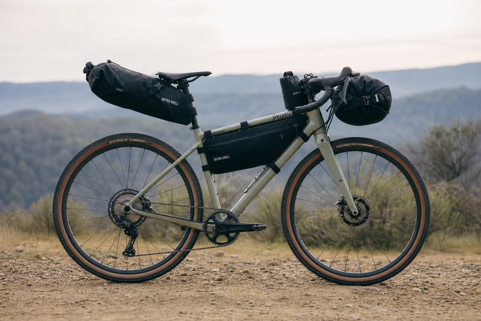 Ciclista su bici gravel carico di diverse borse Outer Shell pronto per il bikepacking